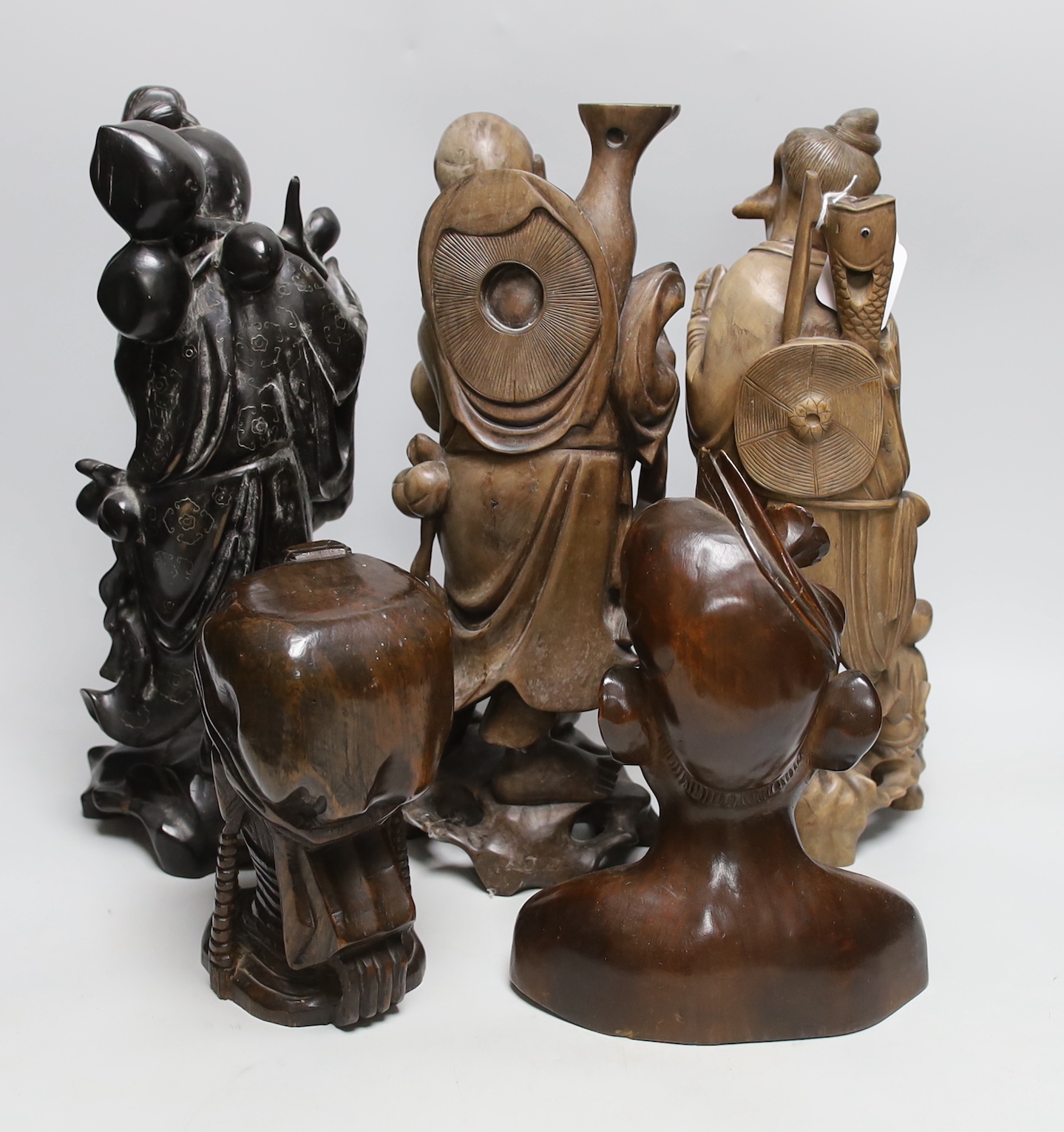 Three Chinese hardwood carvings of immortals and two African hardwood busts, tallest 38cm